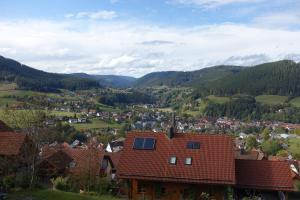 a town with a red roof and mountains in the background at Ferienwohnung am Hirschkopf in Baiersbronn