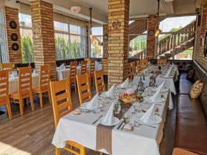 une salle à manger avec des tables et des chaises blanches dans l'établissement OLIMPIA VILLA, à Tibodu