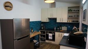 a kitchen with white cabinets and a refrigerator at Casa Três Picos in Horta