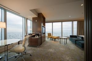 a living room with a couch and a table and chairs at Osaka Marriott Miyako Hotel in Osaka
