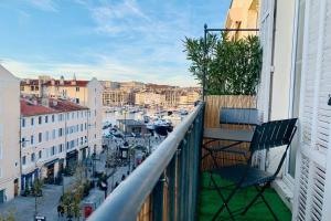 a chair sitting on the balcony of a building at Le Phocéen : T4 balcon vue Vieux-Port in Marseille