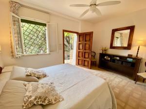 a bedroom with a bed with a ceiling fan and a window at Villa Don Giovanni Taormina Mare in Taormina +26 photos