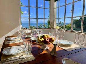 a dining room table with a bowl of fruit on it at Villa Don Giovanni Taormina Mare in Taormina