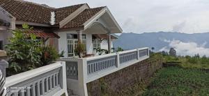 een klein huis met een witte leuning aan een muur bij Good Karma Guesthouse in Bromo