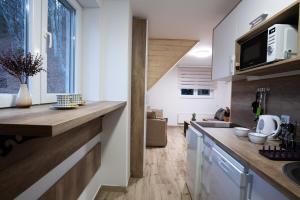 a kitchen with white walls and wooden countertops at Brzece Ski-Lift Apartments in Brzeće