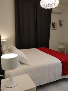 1 dormitorio con cama blanca y lámpara de araña en Villa Beatrice en Brescia