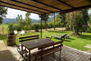 una mesa de picnic y bancos en un parque en Le Pettegole del Boschetto, en Castiglione della Pescaia