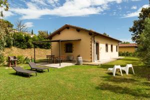 Una pequeña casa con sillas en un patio. en Le Pettegole del Boschetto, en Castiglione della Pescaia 46 fotos más