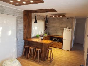 uma cozinha com um balcão com bancos e um frigorífico em Costa Lobo em Pichilemu