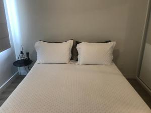 a bed with two white pillows in a room at Apartamento Frente ao Mar Santos in Santos