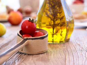 a container of tomatoes on a table next to a bottle at Artemis Seaside Resort in Paliochori