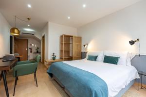 a bedroom with a large bed and a desk and a room at Feel Corporate Housing Marquês in Porto