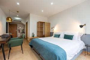 a bedroom with a large bed and a desk and a room at Feel Porto Corporate Housing Marquês in Porto