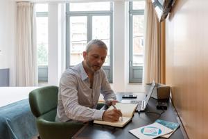 a man sitting at a desk with a laptop at Feel Porto Corporate Housing Marquês in Porto