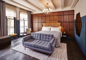 a bedroom with a bed and a couch at The Hoxton, Amsterdam in Amsterdam