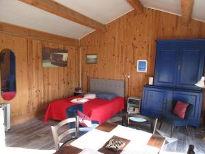 1 dormitorio con cama roja y armarios azules en Espace Nature Studio indépendant proche du Parc des oiseaux en Sainte-Olive