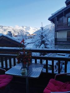 une table avec un arbre de Noël sur un balcon dans l'établissement Appartement Courchevel le Praz, à Courchevel