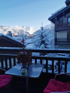 a table with a christmas tree on a balcony at Appartement Courchevel le Praz in Courchevel