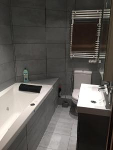 Appartement Courchevel le Praz في كورشوفيل: حمام مع حوض وحوض استحمام ومرحاض