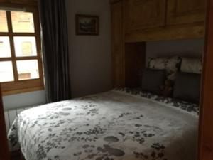 a bedroom with a bed and a window at Appartement Courchevel le Praz in Courchevel