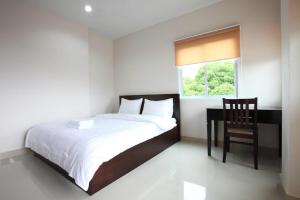 um quarto com uma cama, uma cadeira e uma janela em Garden Hill Hotel em Trang