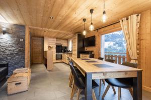 uma cozinha e sala de jantar com uma mesa de madeira e cadeiras em Chalet Socali Le Grand Bornand em Le Grand-Bornand