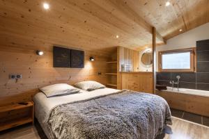 um quarto com uma cama e uma banheira num quarto em Chalet Socali Le Grand Bornand em Le Grand-Bornand