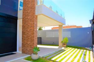 Casa con balcón con 2 macetas en Casa de Luxo na Praia - Sun Luxury Home, en Aracaju