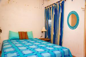 1 dormitorio con cama y espejo en La Felicidad, en Puerto Peñasco