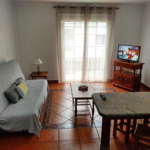 a living room with a couch and a tv at Apartamentos Isora in Frontera