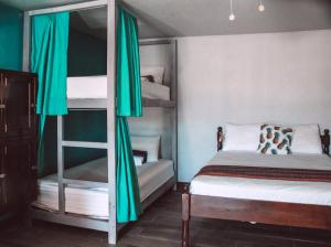 
a bedroom with a bed and two bunk beds at Drift Inn San Pedro in San Pedro
