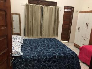 Chalés da Boneca في إيكابوي: غرفة نوم بسرير ازرق ونافذة
