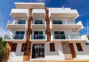 a tall white building with balconies on it at Hotel Casa Pridda in Puerto Escondido