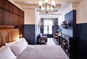 Schlafzimmer mit blauen Wänden, einem Bett und einem Stuhl in der Unterkunft The Hoxton, Amsterdam in Amsterdam
