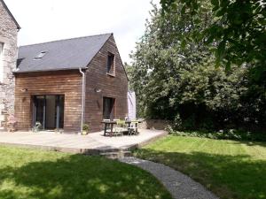 a house with a wooden deck in the yard at La petite brise in Plouër-sur-Rance