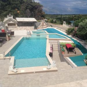 a large swimming pool with blue water in a house at Villa Tamara,3 beheizte Pools,Meerblick in Škrip