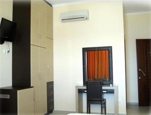 a room with a desk with a chair and a television at Entheon Rooms in Marathopolis