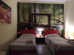 a room with two beds and a mirror on the wall at B&B Country House Crema in Crema