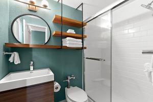 a bathroom with a toilet and a sink and a shower at The Beachcomber St. Pete Beach Resort & Hotel in St. Pete Beach