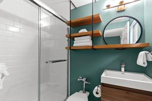 a bathroom with a shower and a toilet and a sink at The Beachcomber St. Pete Beach Resort & Hotel in St. Pete Beach +13 photos
