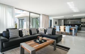 uma sala de estar com um sofá preto e uma mesa em Colinas do Golfe Vilamoura Sun by SAPvillas em Vilamoura