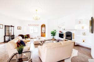 uma sala de estar com mobiliário branco e uma lareira em Villa Grace Bay by Algarve Vacation na Guia