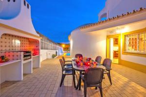 um pátio com uma mesa e cadeiras e uma cozinha em Villa Grace Bay by Algarve Vacation na Guia