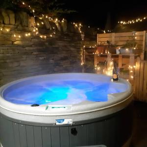 a hot tub in a backyard at night with lights at Castle Hideaway in the Cotswolds in Chipping Campden
