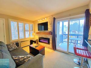 a living room with a couch and a fireplace at Classy Mountainside Studio in Blue Mountains