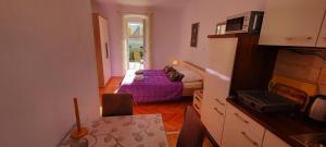un petit salon avec un lit et une table dans l'établissement Apartments Villa Beba, à Komiža