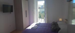 une chambre avec un lit et une grande fenêtre dans l'établissement Apartments Villa Beba, à Komiža