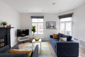 a living room with a blue couch and a tv at homely – Central London West End Apartments in London