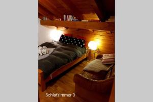 a bedroom with a bed and a couch in a room at Chalet BANULARA Platz für 14 Personen auf drei Etagen in Bellwald