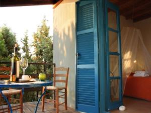 a table and a blue door on a patio at Skites Hotel Bungalows in Ouranoupoli